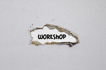 The word workshop appearing behind torn paper