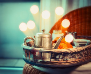 Early cozy breakfast  with coffee on tray at bokeh light