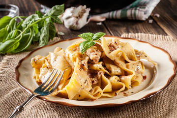 Pappardelle pasta with prosciutto and cheese sauce on a plate