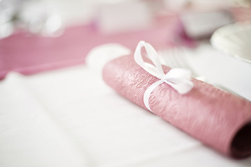 Rolled paper napkin tied with a white ribbon