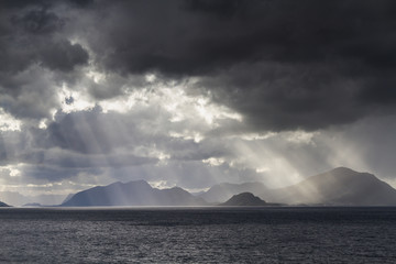 Fototapeta na wymiar Sunbeams at a fjord near Alesund