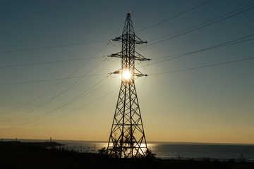 beautiful landscape with high voltage pylon near the river at the sunset