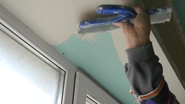 The process of applying the second layer of putty spatula on the sides of the window