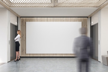 People and large horizontal poster in office lobby