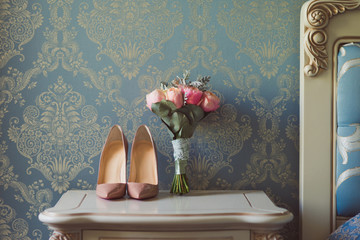 Bridal bouquet and beige leather shoes during preparation at wedding in the morning