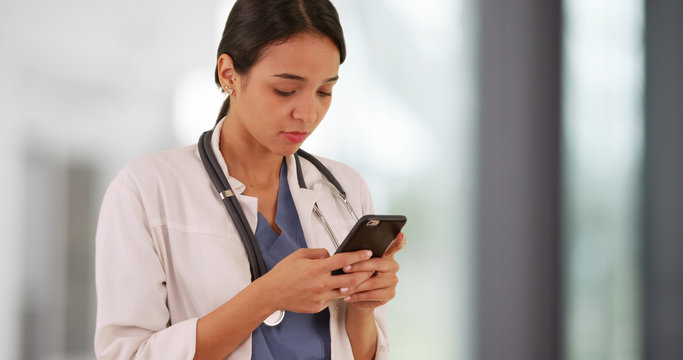 Latina Doctor Texting On Smartphone