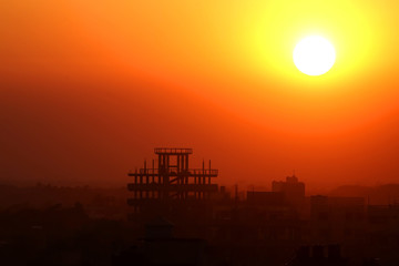 Fototapeta na wymiar Setting sun behind construction building