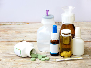 cold medicines on a light background - pill, syrup, drop, ampoule, syringe