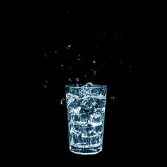 Glass of Water with Ice and Splashes isolated on black