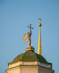 Sculpture of an angel with a cross on the steeple of the church