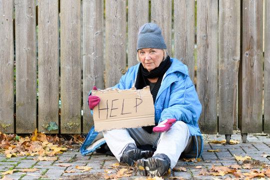 Elderly homeless woman begging on the street