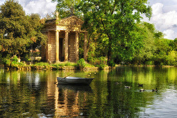 Park Villa Borghese, Rome, Italy. Reflection in lake with boat and ducks