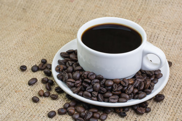 White cup with coffee drink on jute bag background