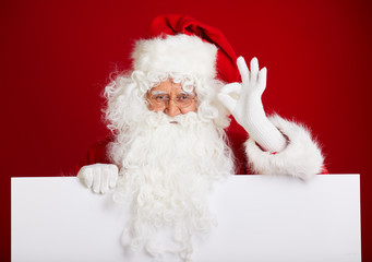 Santa Claus pointing in blank advertisement banner isolated on r