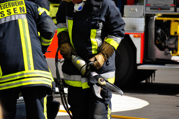 Zwei Feuerwehrleute mit der Rettungsschere im Einsatz bei einem Verkehrsunfall (realistische Übungssituation)