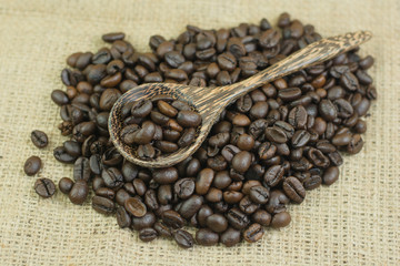 coffee beans and wood spoon on jute bag background