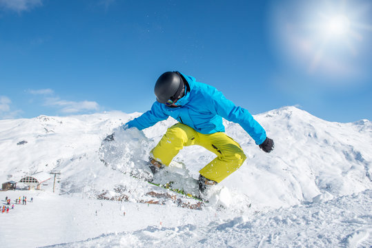 Young snowboarder in protective gear jumping