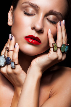 Young woman  with  with many bijouterie rings with stones on fin