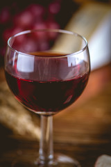Glass of wine on wooden table, atmospheric composition