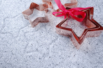 Copper star-shaped cookies cutter for Christmas on shiny mirrore