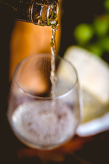 Man is pouring white wine into the glasses