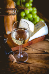 Man is pouring white wine into the glasses