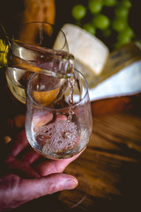 Man is pouring white wine into the glasses
