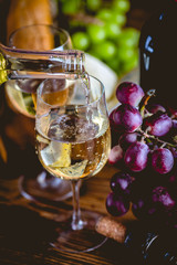 Man is pouring white wine into the glasses