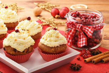 Chocolate cupcakes with cranberries on christmas festive table.