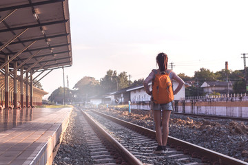 Orange helmet and backpack at the train station with tourists. Travel ideas