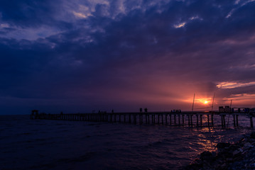 Fototapeta na wymiar Filed wooden bridge into the sea at sunset in Thailand