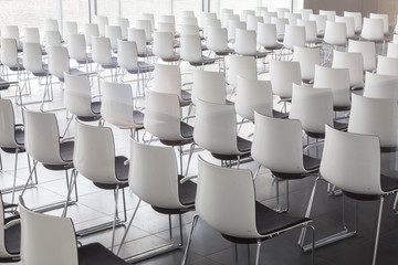 Interior of empty contemporary conference hall with white chairs.