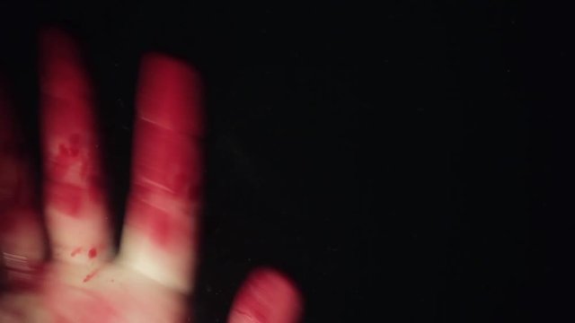 Bloody hand on window glass deep dark background