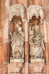 Fototapeta na wymiar Statues of Saint Rupert - the founder of Nonnberg Abbey, and his niece Saint Erentrude - the first abbess of Nonnberg Abbey. Portal of the collegiate church of Nonnberg Abbey.