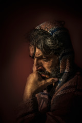 Man with Hood in Deep Thought and Wistfully view
Portrait of a man with a beard looking down...