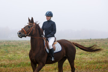 Woman horseback riding in the field