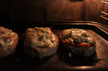 ciabatta slices with melted cheese inside an oven