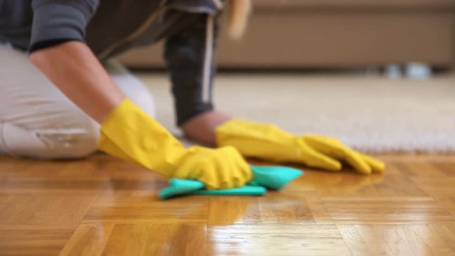 Housewife violently cleans parquet floors. Dolly shot.