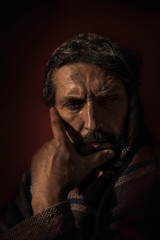 Man with Hood in Deep Thought and Wistfully view
Portrait of a man with a beard looking down thoughtfully and with his hand holding his head. His head is covered with a hood
