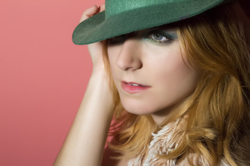 Portrait of a beautiful young girl in a green hat