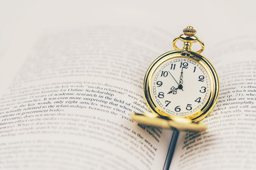 Vintage pocket watch on book with copy space.Time for study or reading concept.