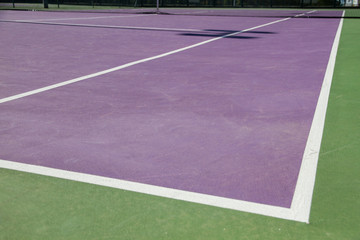 Fototapeta premium Lines of the corners of a cement tennis court. Track colors are purple and green. 