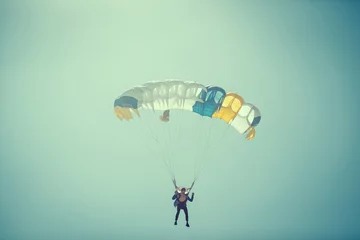 Cercles muraux Sports aériens Parachutiste Sur Parachute Coloré Dans Un Ciel Clair Ensoleillé.