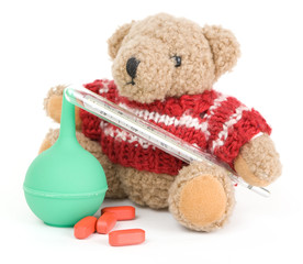 Teddy Bear with red pills, green enema and vintage mercury thermometer on a white background - 124518045