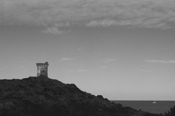 Tour Génoise sur une colline en bord de mer, Corse, France, noir et blanc 