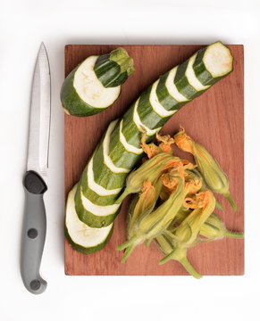 sliced zucchini with organic flowers on chopping board
