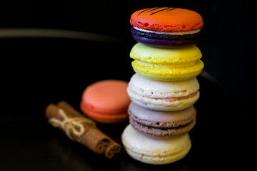 view from top point to vivid colored macaroons in stack on each other on black background/more free space/different focus point/landscape orientation