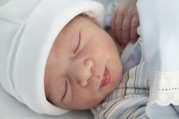 newborn with hours sleeping in the hospital with a hat