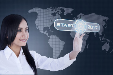 Female worker presses start button