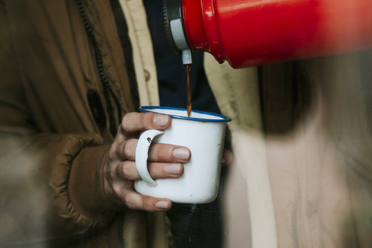 Pouring Coffee Thermos In The Cup After The Window